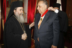 Ο Μακαριώτατος δίδει στον Πρέσβυ σταυρό.