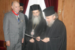 Ο Γέρων Αρχιγραμματεύς αναγιγνώσκει τον τίτλο της παρασημοφορήσεως