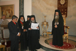 Ο Γραμματεύς της Ιεράς Συνόδου αναγιγνώσκει τον τίτλο της παρασημοφορήσεως
