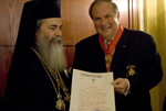 Ο κ. Λυμπεράκης κρατά το δίπλωμα του απονεμηθέντος σε αυτόν παρασήμου