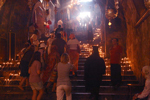 Devout believers placing lit candles on the church steps