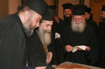 Ο Μακαριώτατος με τον π. Κελαδίωνα διανέμει την πίττα στους Πατέρες